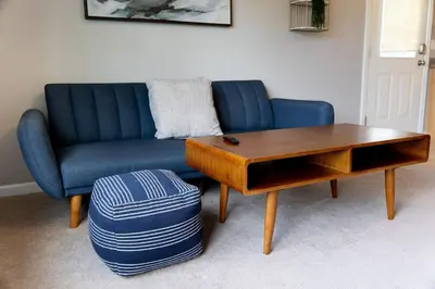 a living room with a blue couch and a coffee table at 2 Beautiful 1 BR Apartment - Central CT in Plainville