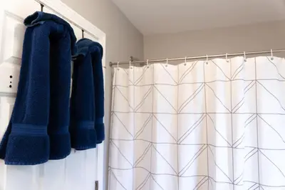 a bathroom with blue towels and a shower curtain at 2 Beautiful 1 BR Apartment - Central CT in Plainville