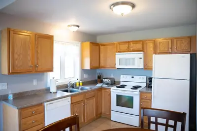 a kitchen with white appliances and wooden cabinets at 2 Beautiful 1 BR Apartment - Central CT in Plainville