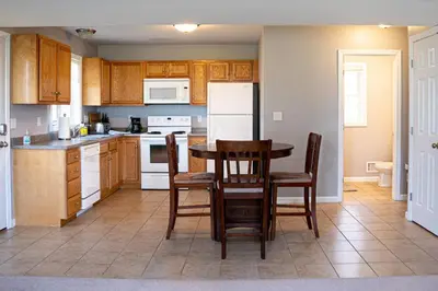 a kitchen with a table and chairs and a refrigerator at 2 Beautiful 1 BR Apartment - Central CT in Plainville