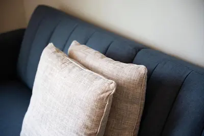 two pillows sitting on top of a blue couch at 2 Beautiful 1 BR Apartment - Central CT in Plainville