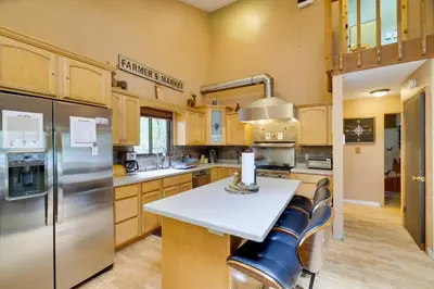 a kitchen with wooden cabinets and stainless steel appliances at Secluded Cabin, Jacuzzi, Pool Table, King Bed & Fire Pit in Bushkill