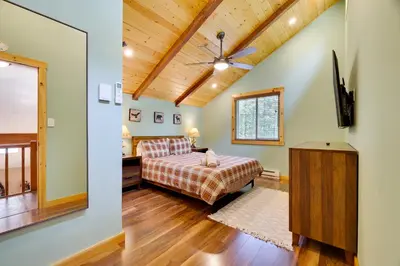 a bedroom with a bed and a ceiling fan at Secluded Cabin, Jacuzzi, Pool Table, King Bed & Fire Pit in Bushkill