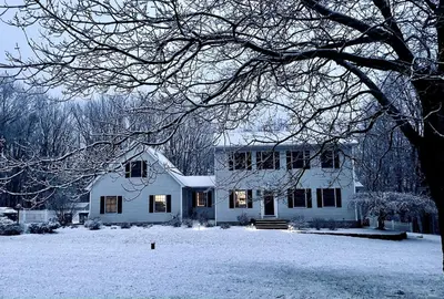 a white house with snow on the ground at Beautifully Designed 4BR Home Heated Pool HotTub in Valatie