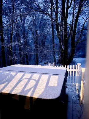 a snow covered bench next to a white fence at Beautifully Designed 4BR Home Heated Pool HotTub in Valatie