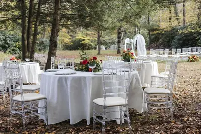 a table with white tables and chairs with flowers on it at Pocono River front Home near Camelback Resort in Barton Glen