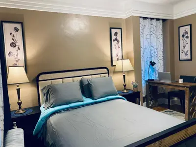 a bedroom with a bed and two lamps and a desk at NYC cozy room in Van Nest