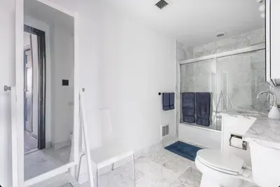 a white bathroom with a toilet and a shower at Doorman! High Floor! Views! Elevator! Free Gym! in New York