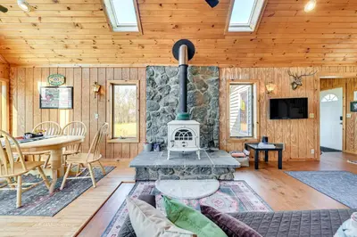 a living room with a stone fireplace in a house at 3 Mi to Catskill Trail Stamford Cottage with Views in Stamford