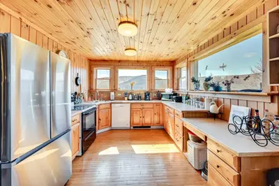a kitchen with wooden cabinets and a refrigerator at 3 Mi to Catskill Trail Stamford Cottage with Views in Stamford