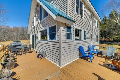 a house with a deck with chairs and a table at 3 Mi to Catskill Trail Stamford Cottage with Views in Stamford