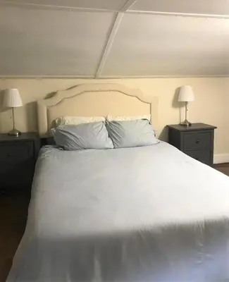 a bedroom with a white bed with two lamps at Charming Hudson Valley 3-Bedroom Family Getaway in Tomkins Cove