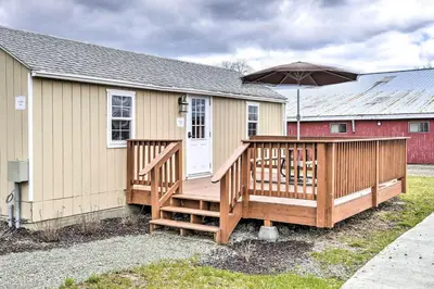 a house with a large deck with an umbrella at 12 Bedroom Estate Experience 100 Acre Near Ski Area in Pleasant Mount