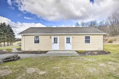 a small yellow house in a field at Home Away from the City Close to Ski Trails in Pleasant Mount