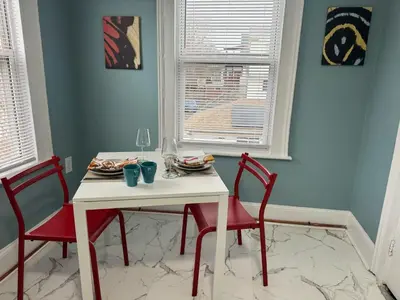 a dining room table with two red chairs and a white table at Private room in a shared apt Middletown near Wesley uni in Middletown