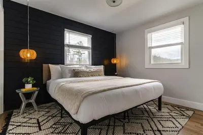 a bedroom with a large bed and two windows at Perch Cottages #5 - Creek Access, Sauna, Mt views in Boiceville