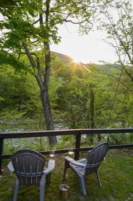 two chairs and a table on a porch with a view at Perch Cottages #7 - Creek Access, Sauna, Mt views in Boiceville