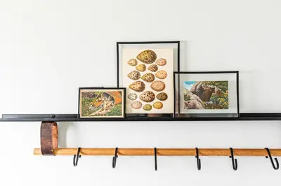 a shelf with three framed pictures on top of it at Perch Cottages #9 - Creek Access, Sauna, Mt views in Boiceville