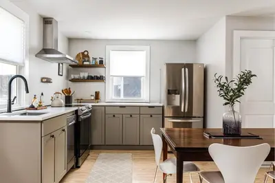 a kitchen with a table and a stainless steel refrigerator at Perch Cottages #11 - Creek Access, Sauna, Mt views in Boiceville