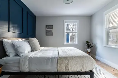 a bedroom with a bed with blue walls and windows at Perch Cottages #13 - Creek Access, Sauna, Mt views in Boiceville
