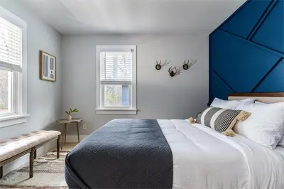 a bedroom with a large bed with a blue headboard at Perch Cottages #15 - Creek Access, Sauna, Mt views in Boiceville