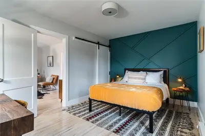 a bedroom with a bed and a blue wall at Perch Cottages #15 - Creek Access, Sauna, Mt views in Boiceville