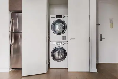 two washing machines in a room with a refrigerator at Blueground Midtown S gym AC nr Empire St NYC-1591 in New York