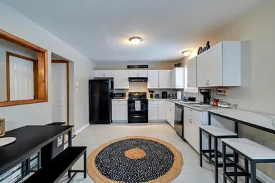 a kitchen with white cabinets and a black refrigerator at Pool Access! All-Season Family Home in Poconos in Crescent Lake