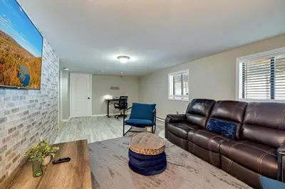 a living room with a leather couch and a table at Pool Access! All-Season Family Home in Poconos in Crescent Lake