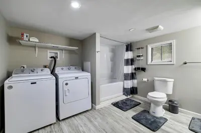 a bathroom with a washer and dryer and a toilet at Pool Access! All-Season Family Home in Poconos in Crescent Lake