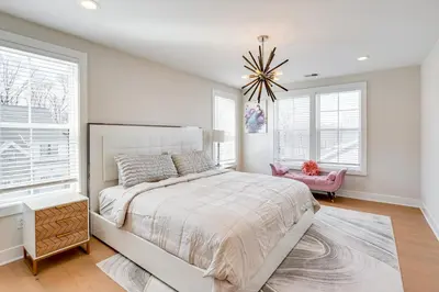 a white bedroom with a large bed and windows at 10 Mi to Morristown Stylish Home Near Trails! in Denville
