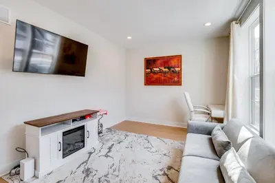 a living room with a couch and a tv at 10 Mi to Morristown Stylish Home Near Trails! in Denville
