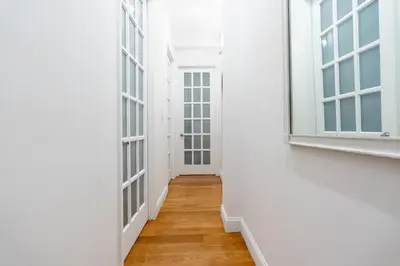an empty hallway with windows and a wooden floor at Prestige NYC Suite in New York