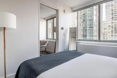 a bedroom with a bed and a large window at UWS 1BR w WD nr Lincoln Center NYC-1187 in New York