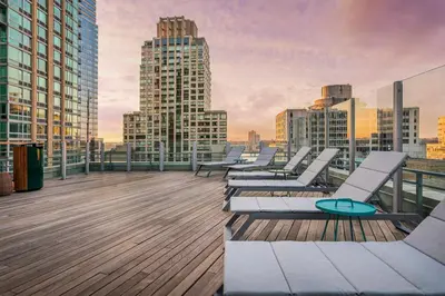 a row of lounge chairs on the roof of a building at UWS 1BR w WD nr Lincoln Center NYC-1187 in New York