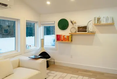a living room with a white couch and windows at Peaceful Catskills Creek House in Saugerties