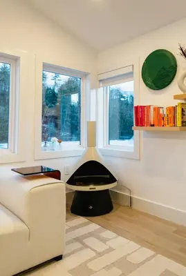 a living room with a fireplace in the middle of the room at Peaceful Catskills Creek House in Saugerties