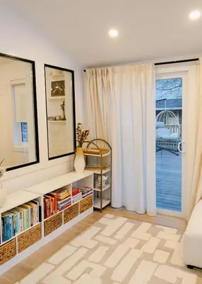 a living room with a book shelf and a window at Peaceful Catskills Creek House in Saugerties