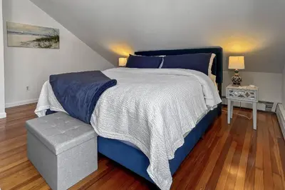 a bedroom with a large bed with a blue comforter at Grove Place Beach West Haven in West Haven