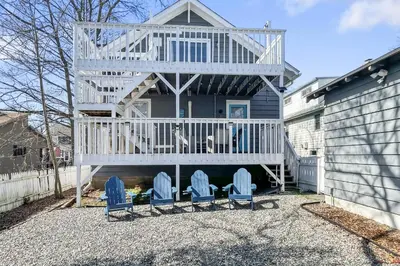 a house with two blue chairs and a deck at Grove Place Beach West Haven in West Haven