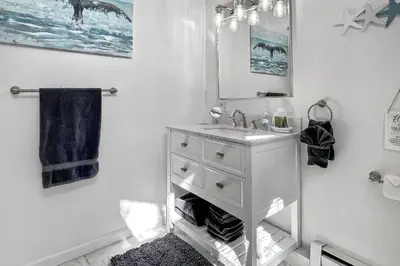 a white bathroom with a sink and a mirror at Grove Place Beach West Haven in West Haven
