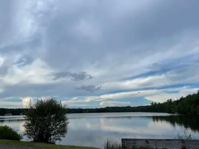 a lake with a bench in front of it at Pocono Escape - Modern & Cozy in Pocono Summit