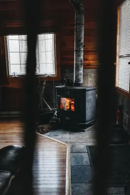 a living room with a wood stove in a cabin at Colonels Cabin Sauna, Fireplace, Mountain Views in Lanesville