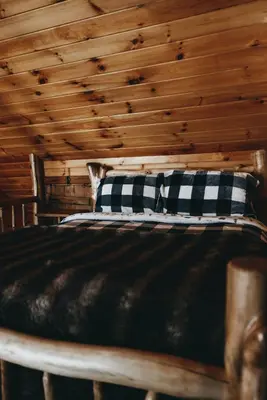 a bed in a room with a wooden ceiling at Colonels Cabin Sauna, Fireplace, Mountain Views in Lanesville