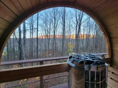 an arched window with a view of a forest at Colonels Cabin Sauna, Fireplace, Mountain Views in Lanesville