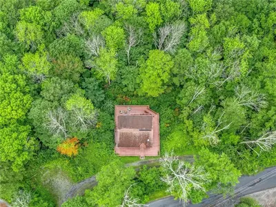 an overhead view of a forest with a building in the middle at Colonels Cabin Sauna, Fireplace, Mountain Views in Lanesville