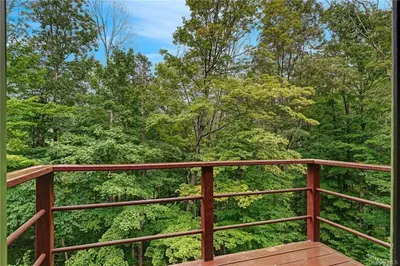 a wooden deck with trees in the background at Colonels Cabin Sauna, Fireplace, Mountain Views in Lanesville