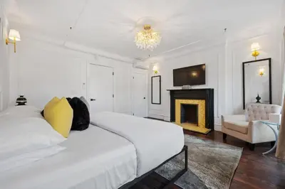 a white bedroom with a bed and a fireplace at The Perfect Apt for Large Groups Sleeps 10 in New York