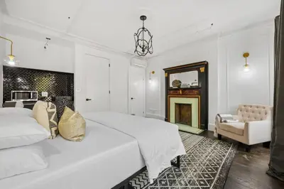 a white bedroom with a large bed and a fireplace at The Perfect Apt for Large Groups Sleeps 10 in New York