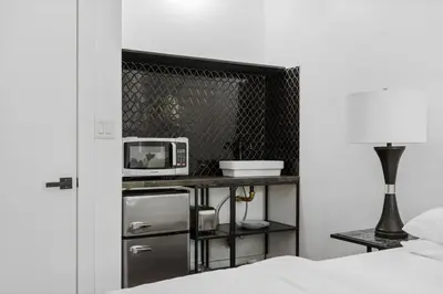 a room with a bed and a table with a microwave at The Perfect Apt for Large Groups Sleeps 10 in New York